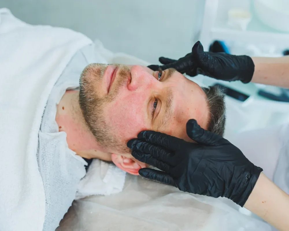 a-cosmetologist-cleans-the-skin-of-a-man-s-face