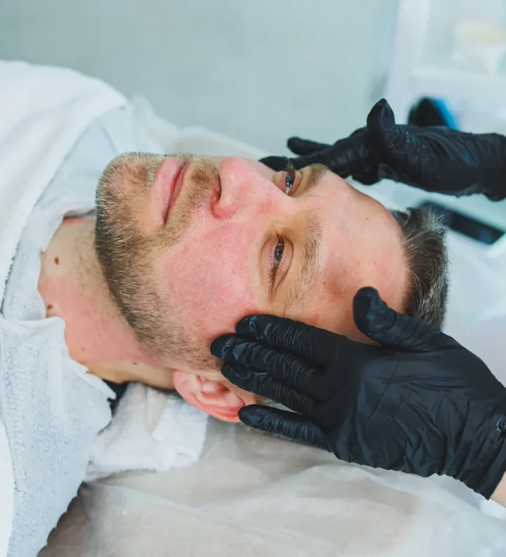 a-cosmetologist-cleans-the-skin-of-a-man-s-face